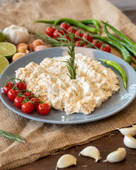 Ali nazik meze, a traditional Turkish dish of yoghurt and eggplant puree topped with a mint leaf. Side dish for kebab in a clay plate on a wooden background with spear space. Flat lay
