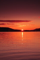 Obraz premium 太陽の光に紅く染まる湖の風景。陽光の下のカルデラ湖の明媚な瞬間。