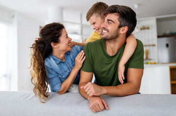 Happy family. Beautiful young parents having fun, playing with their son at home.