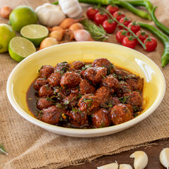 Traditional spicy meatballs in tomato sauce on wooden background. Selective focus