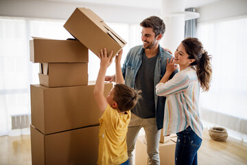 Happy family with cardboard boxes in new house at moving day.