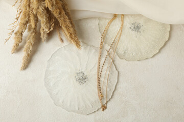 Epoxy resin, fabric, golden chain and field flowers on white background