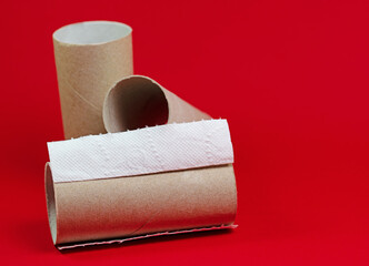 Aufgebrauchte Klopapierrollen vor rotem Hintergrund