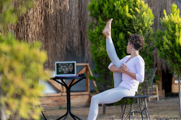 Yoga trainer holding online class during pandemic Coronavirus. Fitness coach teaching yoga online...
