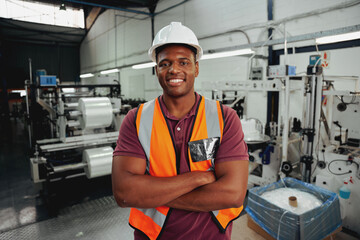 Cheerful confident young african male industrial worker looking at camera with his arm crossed