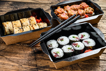 The sushi rolls in the delivery package, ordered in sushi take-out restaurant.  Wooden background. Top view