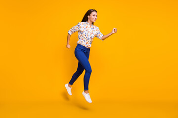 Fototapeta na wymiar Full length photo portrait of woman running forward jumping up isolated on vivid yellow colored background