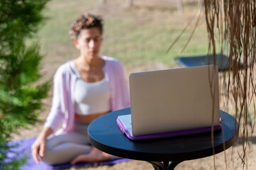 Yoga trainer holding online class during pandemic Coronavirus. Fitness coach teaching yoga online...