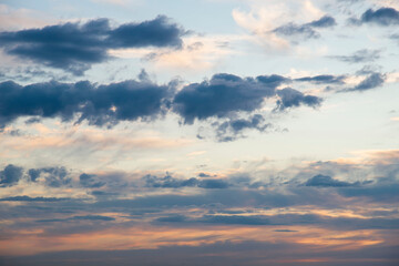 Dramatic multicolored clouds in the sky at sunset. Natural blue-orange background