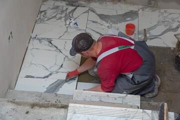 A working specialist in laying ceramic tiles does his job