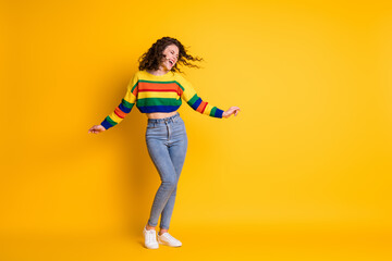 Full length photo of girl dance open mouth crazy face wear striped cropped pullover jeans footwear isolated yellow color background
