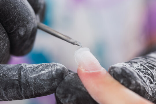 Professional manicure working with nail extension gel - Close-up of a manicurist working on nails.