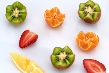 Fresh fruit kiwis and tangerines lie on a light background