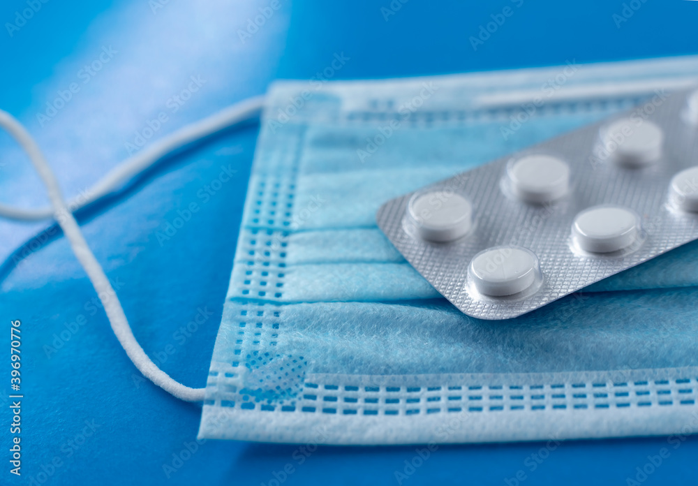 Poster protective mask and pills on a blue background. protection against viruses and bacteria