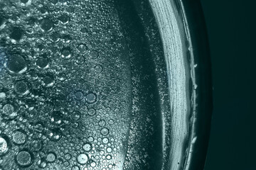 abstract tidewater green background with oil circles . water drops close up . oil bubbles in the...