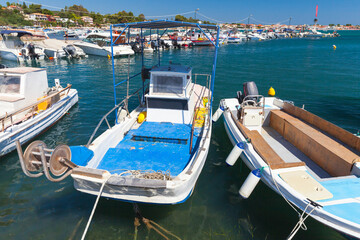 Small wooden fishing boats are moored in port