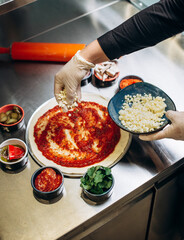 Closeup hand of chef baker making pizza at kitchen