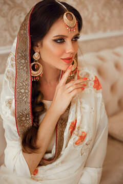 Portrait of beautiful indian girl in traditional saree in luxury interior. Young hindu woman model with kundan golden jewelry set. Indian costume lehenga choli.