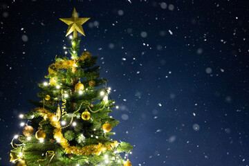 Decorated gold Christmas tree on blue.