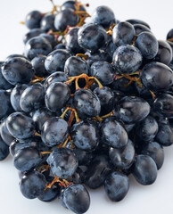 Grapes-clusters of ripe red grapes lie on a white background.Space for text