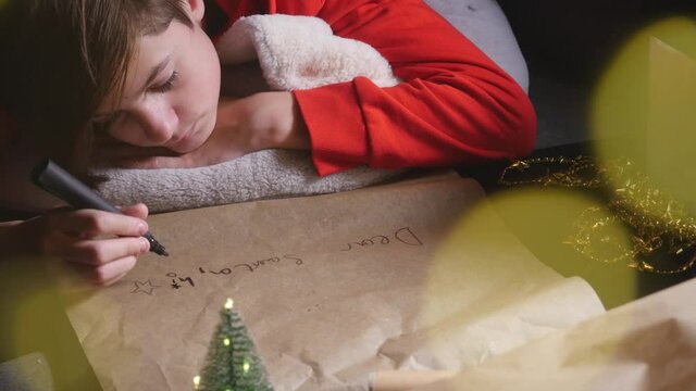 Teenage boy writing long letter to Santa