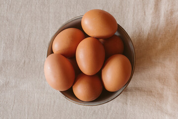 Eggs background. Closeup view of eggs in a bowl on rustic table as background. Organic and healthy food.	