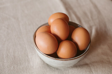 Eggs background. Closeup view of eggs in a bowl on rustic table as background. Organic and healthy food.	