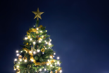 Decorated gold Christmas tree on blue.