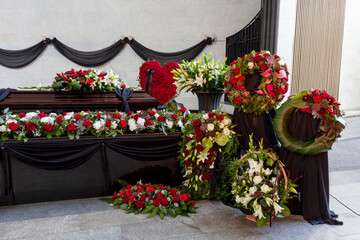 The coffin is decorated with various flowers. A beautiful funeral ceremony.
