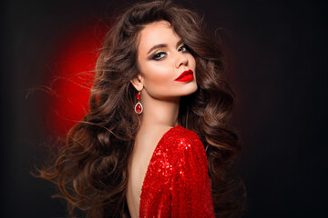 Beautiful sexy brunette in red dress with healthy curly hair and glamour makeup. Fashion Beauty Girl Isolated on black studio Background. - 396978799