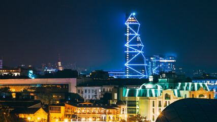 Fototapeta premium Tbilisi, Georgia. Modern Urban Night Cityscape. Evening Night Scenic Top View Of City Center