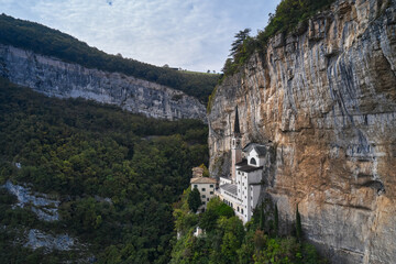 Fototapeta na wymiar The unique Sanctuary Madonna della Corona church in the rock. The sanctuary is high in the mountains of Italy. Aerial view of the church on the sheer cliff. Italian church at high altitude in the Alps