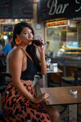 Young lady drinking wine in a bar