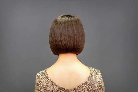 Back view of bob hair of a young woman on dark background