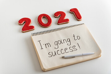 Numbers 2021 and notebook with the words Im going to success. Motivation. Goals for 2021.