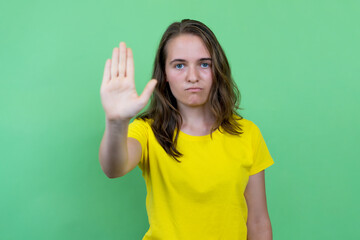 Young woman with brunette hair gesturing stop and distance