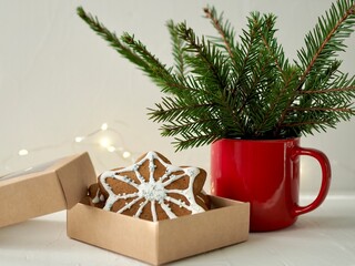 Christmas Red enamel Cup, spruce branches, Christmas cookies in the form of snowflakes on the background of lights