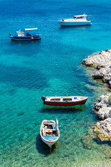 Obraz premium A fishing boat on the sea and Its shadow seen at the bottom easily in Kokkari village.