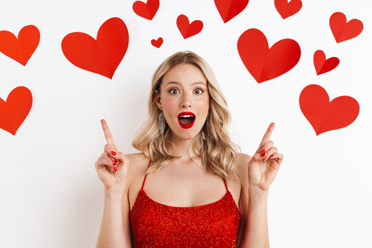 Shocked blonde woman in red dress pointing