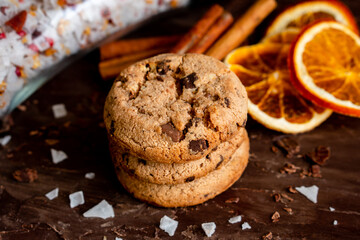 Organic food snack tasty sweet dessert milk dark chocolate chip salt cookie closeup piece fruit orange raspberry hazelnut nuts cinnamon on cocoa cacao powder wooden table for new year Christmas gift