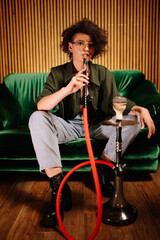 beautiful stylish young gril chilling smoking hookah on green sofa, narghile girl