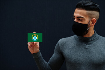 Egyptian man in gray turtleneck and black face protect mask show Ismailia flag isolated background. Governorates of Egypt coronavirus concept.