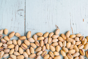 A row of pistachios on a blue wooden background