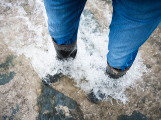 Walking in a river with rubber boots