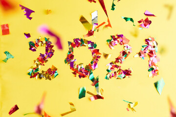 Confetti 2021 on yellow background. New year party