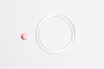  hormone ring and tablets on a white background. Contraceptive ring