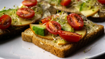 Appetizing and nutritious sandwich with avocado, cheese and tomatoes