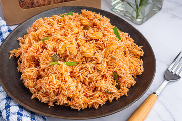 Sweet and sour crispy noodles or Mee krob in the Thai language on a dish with cloth, vase, cutlery placed on a marble table. Top view with copy space for text