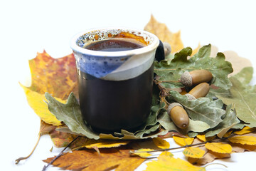 Cup of acorn coffee on autumn leaves