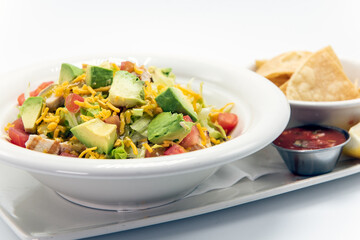 Overhead view of chicken bowl with black beans, sour cream, with rice and cheese filling the bowl.
